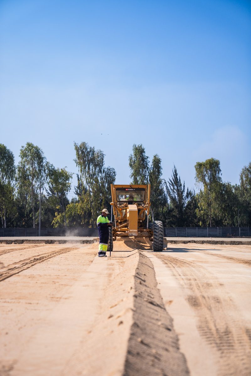 Grader shaping the pavement layers